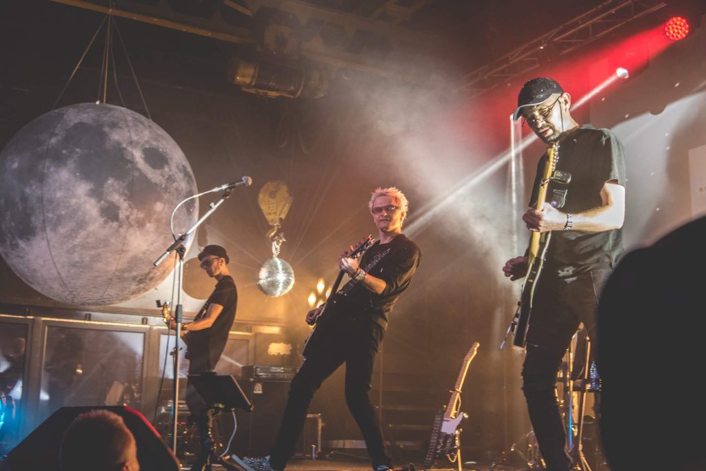Vyrų grupė ant scenos groja gitaromis