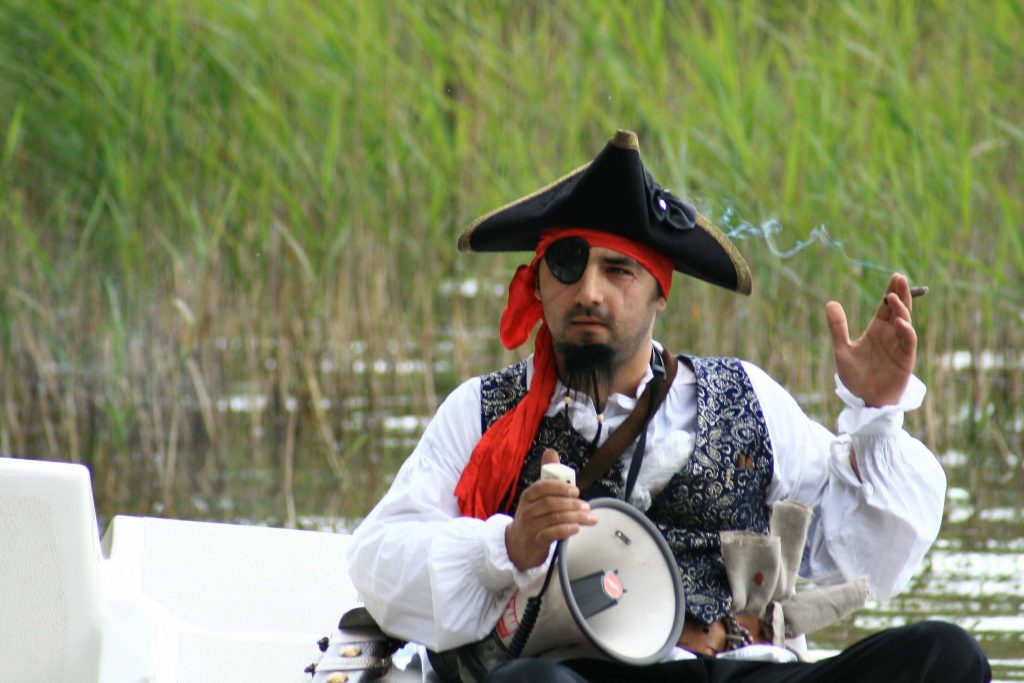 Piratas su kepure ir akies raiščių, rūko cigarą